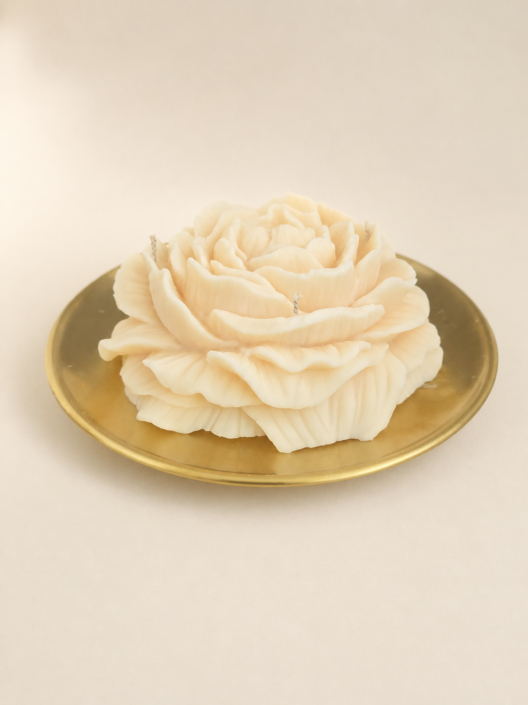 Ivory floral sculptural candle presented in a coordinating vessel