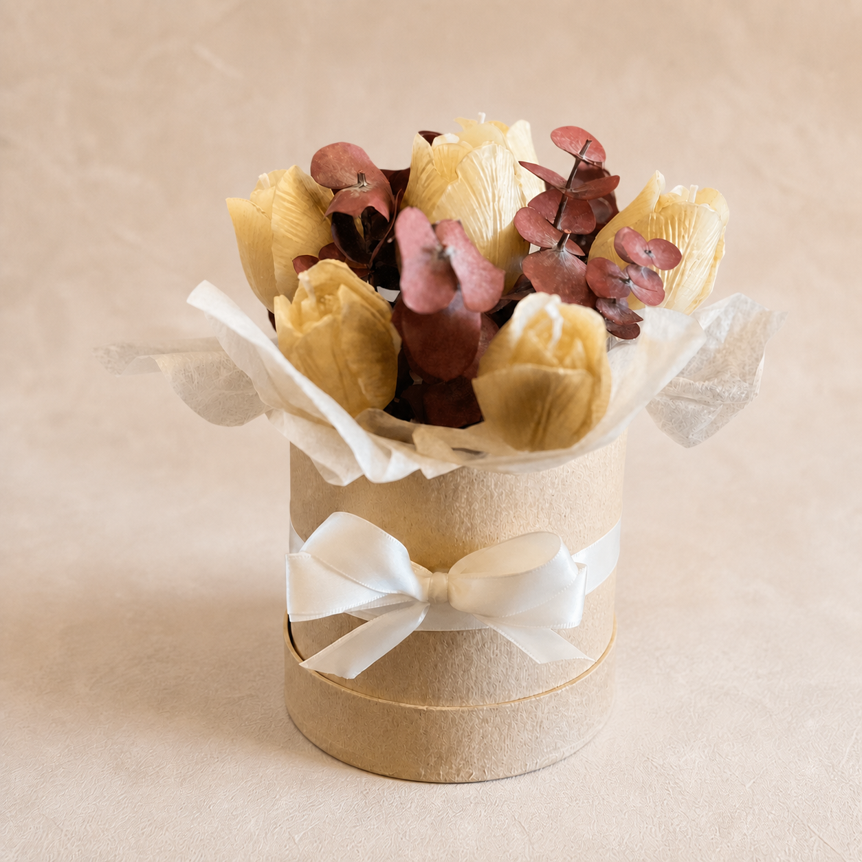 Six warm-toned tulip candles in a small round box