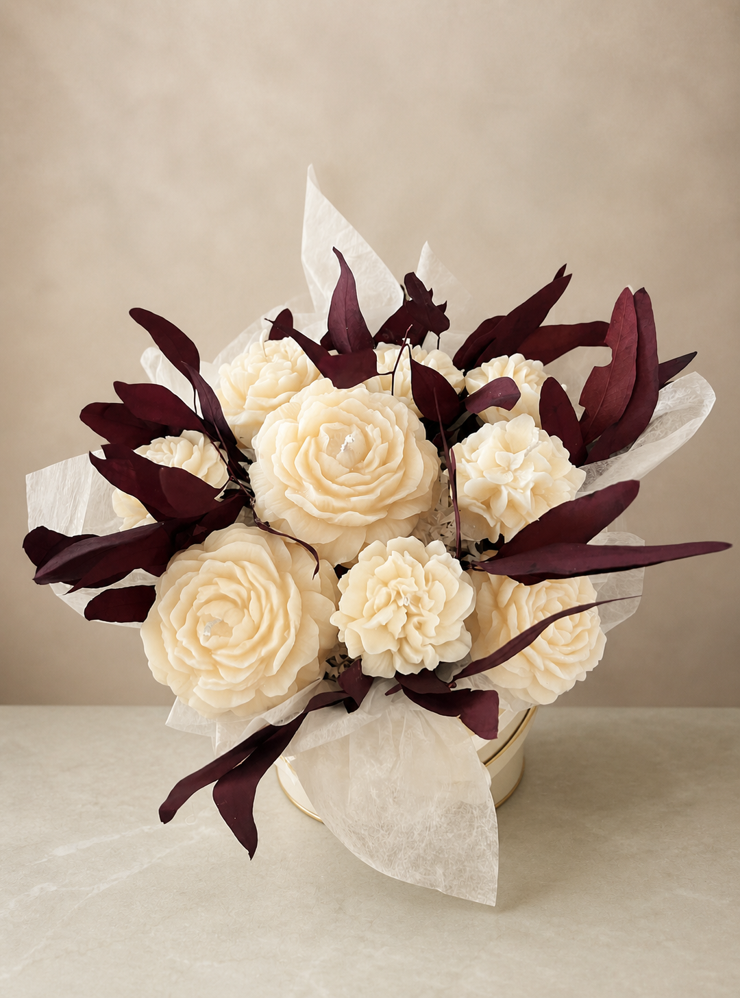Ivory sculptural flower candle bouquet with deep burgundy foliage