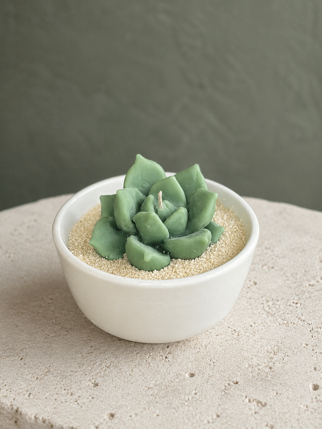 Sage-toned sculptural succulent candle arranged in a low bowl