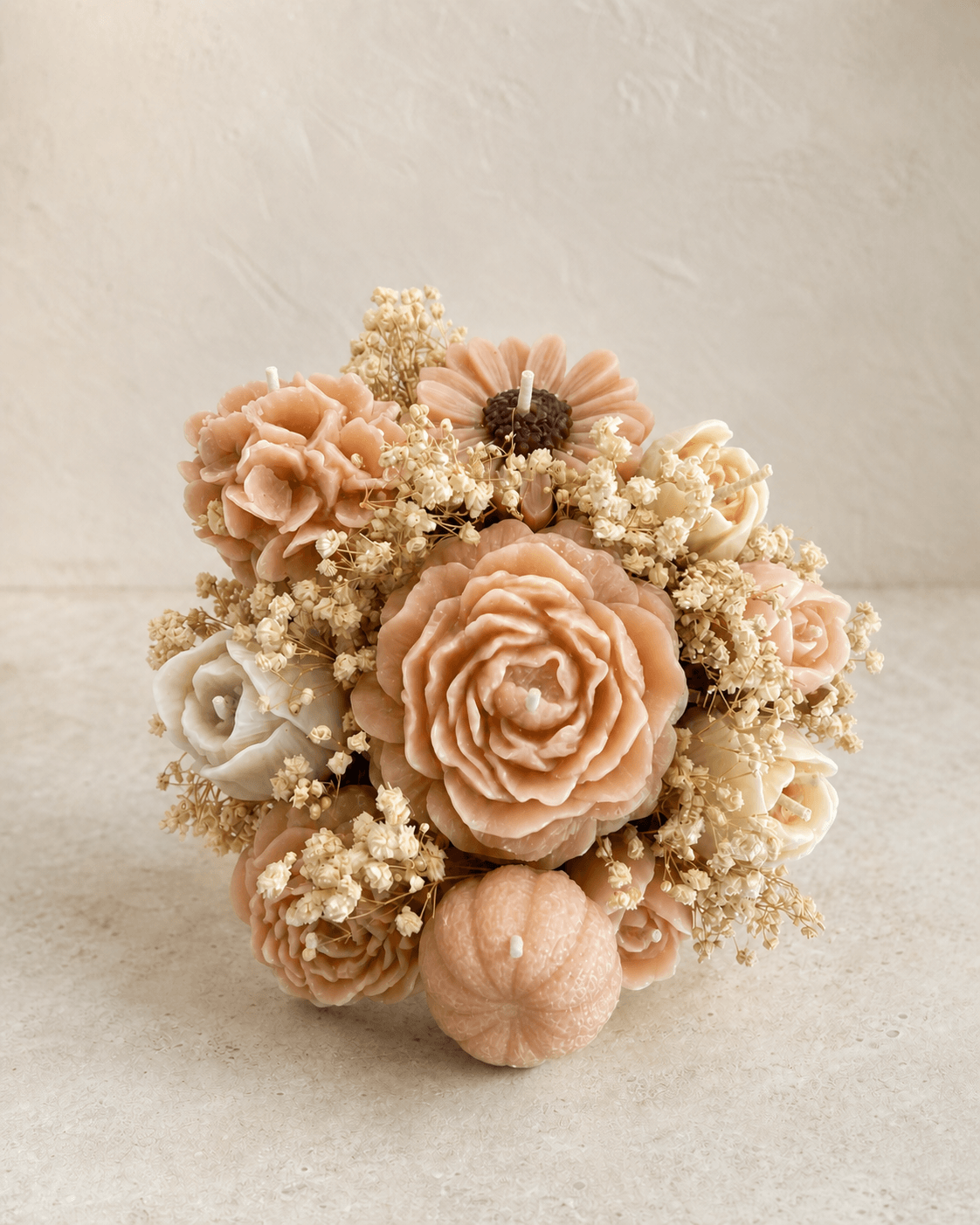 Close view of blush and ivory sculptural wax flowers in a candle bouquet